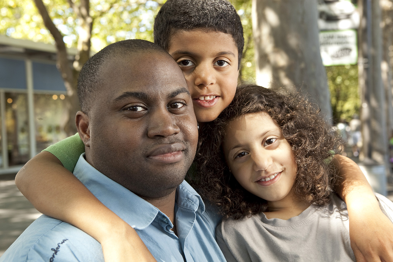 A father holding his two children close