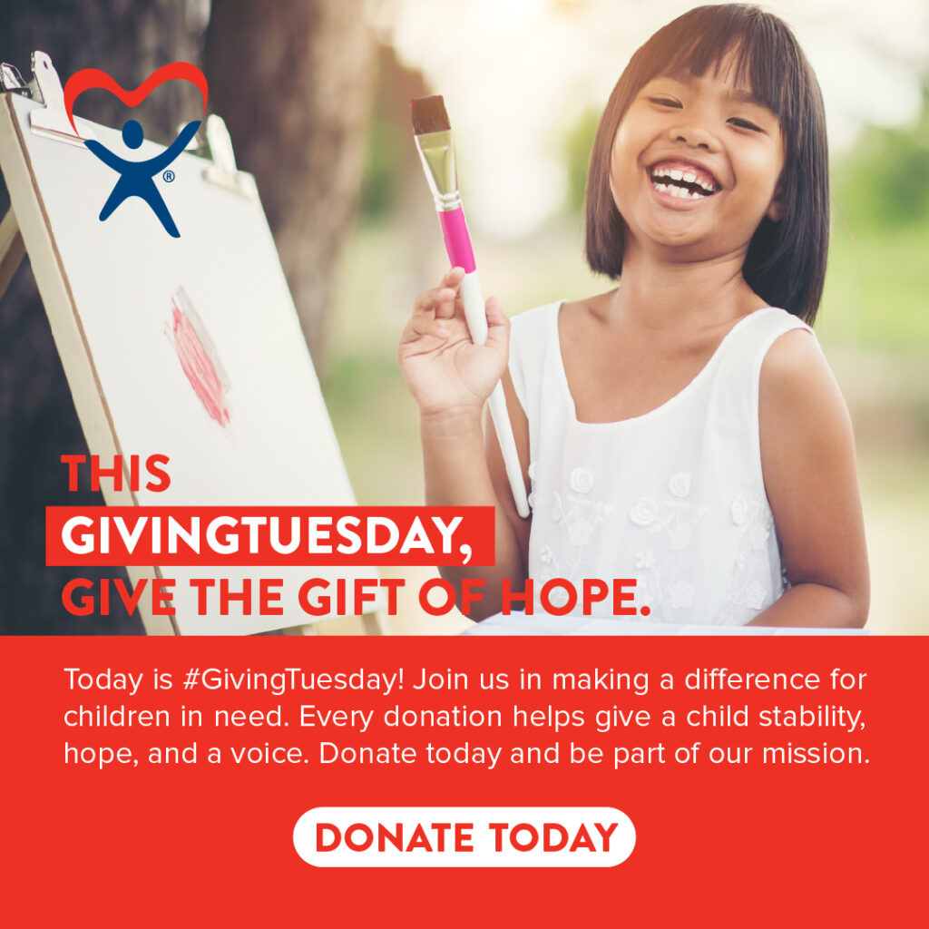 A smiling young girl holding a paintbrush next to her artwork outdoors, featured in a GivingTuesday charitable donation campaign.